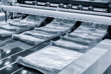 Automatic polyethylene plastic bag production machine with lighting effect. Close-up of the roller...
