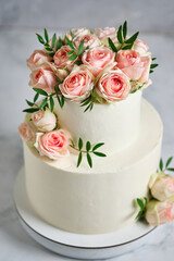 Obraz na płótnie Canvas Delicate wedding bunk cake decorated with roses. White cake to order for a holiday.