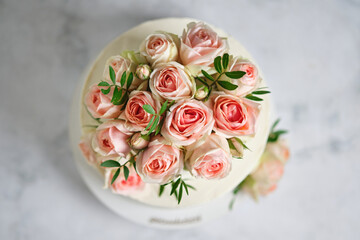 Delicate wedding bunk cake decorated with roses. White cake to order for a holiday.