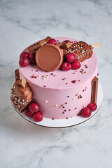 Cake with chocolate on a marble background. Cake decorated with fresh berries and chocolate. Dessert for wedding and birthday. Delicious and beautiful dessert.