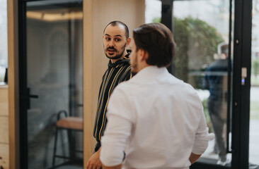 Fototapeta premium Two men engaged in conversation with reflection in glass door.