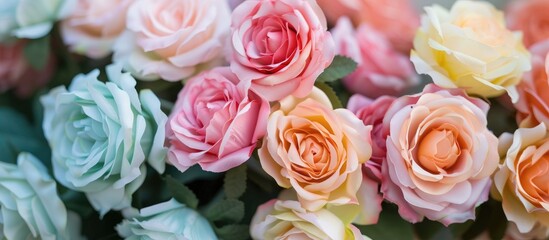 Pastel-colored artificial roses arranged in a bouquet. A top-down perspective.
