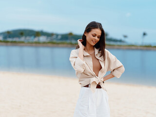 Attractive Female Model Walking Along the Sunny Beach, Embracing the Beauty of Nature and Enjoying a Relaxing Summer Vacation by the Blue Ocean