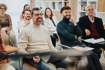 Engaged audience at a casual business presentation or seminar smiling.