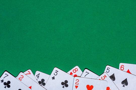 Playing cards on green felt casino table. Background with copy space