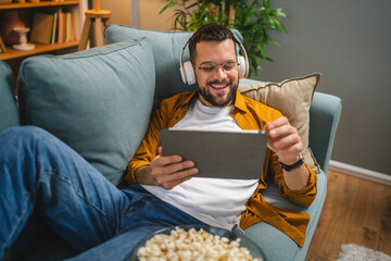 man sit on the sofa bed watch movie video online use digital tablet