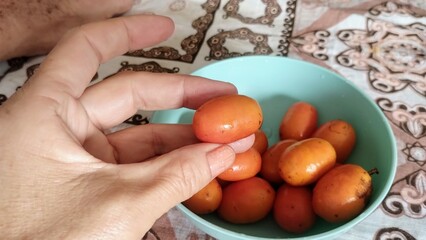 Hand picking fruit from bowl 