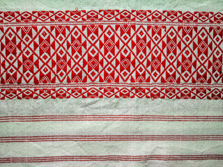 Gamosa or gamusa is a traditional textile pattern from Assam. It is a white piece of cloth with red stripes and red motifs, which is used in Bihu and resembles Ukrainian and Russian patterns. - obrazy, fototapety, plakaty