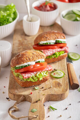 Delicious and fresh sandwich with salami, tomato and cucumber.