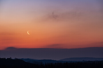 Lune au soleil levant dans un paysage montagneux