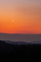 Lune au soleil levant dans un paysage montagneux