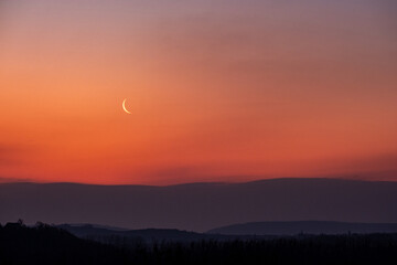Lune au soleil levant dans un paysage montagneux