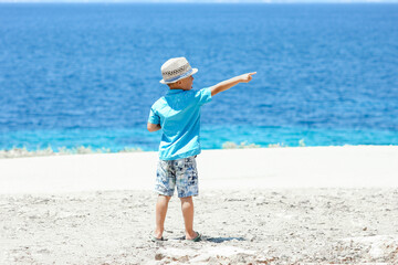 A happy child near the sea in nature on a weekend trip