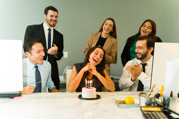 Singing happy birthday to a Hispanic woman in an office