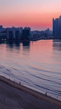 Gwangalli Beach in Busan night to day sunrise timelapse, South Korea. Aerial view, camera pan