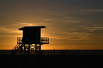 Beach lifeguard's house on stilts at Deauville beach in Normandy against the light of a sunset