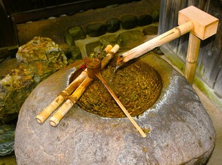 Japanese waterfountain with a bamboo ladle and a stone basin