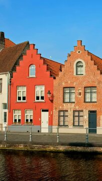Old houses and canal in famous tourist town of Bruges (Brugge) on sunset, Belgium. Camera pan