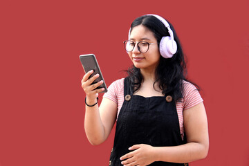 Female Latina teenager of 17 years old uses her cell phone and audio to connect to music, podcast audiobooks and songs with her friends