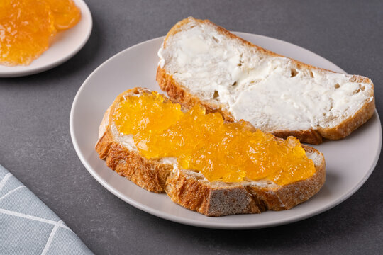 Sandwiches with apricot jam and butter on a gray background