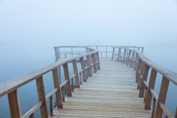 Wooden pier spanning a foggy lake