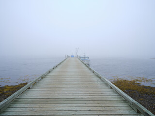 Lobster and fishing boat docked on a long wooden dock in mist and fog - 727396196
