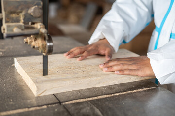 working with wood, hands of a person making a cut with a saw, occupation of carpentry and...