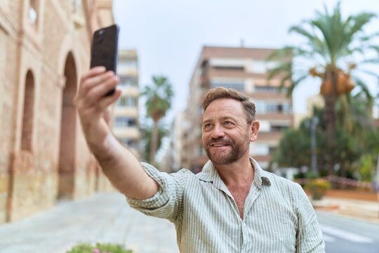 Middle age man smiling confident making selfie by the smartphone at street