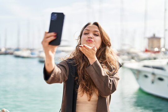 Young beautiful hispanic woman smiling confident making selfie by the smartphone at seaside