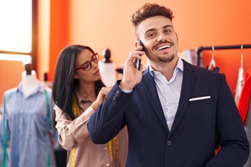 Man and woman tailor measuring jacket of client at atelier