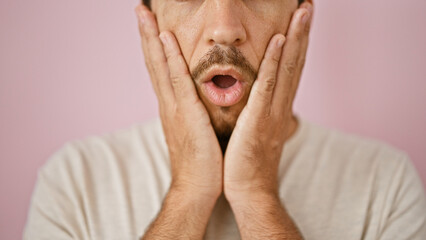 Shocked hispanic man with beard against a pink isolated background showing surprised facial...