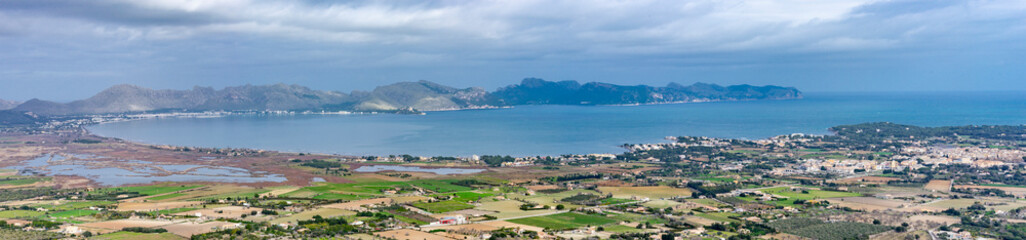 Fototapeta na wymiar Panoramic View of Pollensa Bay in Mallorca with Coastal Towns and Mountain Backdrop