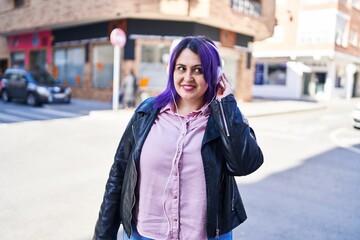 Fototapeta premium Young beautiful plus size woman smiling confident listening to music at street