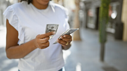 African american woman holding us dollars outside