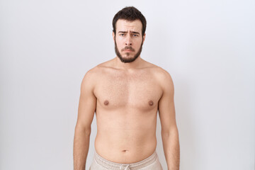Fototapeta premium Young hispanic man standing shirtless over white background depressed and worry for distress, crying angry and afraid. sad expression.