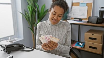 Young adult woman with curly hair examines turkish lira in a modern office setting