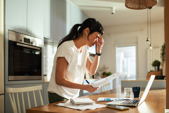 Young asian woman going over bills and home finances at home