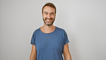 Smiling middle-aged hispanic man with beard posing casually in a blue shirt against an isolated white background.