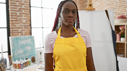 Commanding presence, beautiful, relaxed african american woman artist, donning braids and apron,...