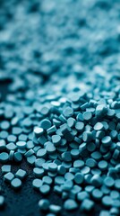 Blue plastic pellets of uniform texture, very small and shiny. Polymer blue plastic granules of different shapes. Reuse of plastic waste in sustainable practices.