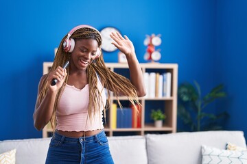 African american woman listening to music singing song at home