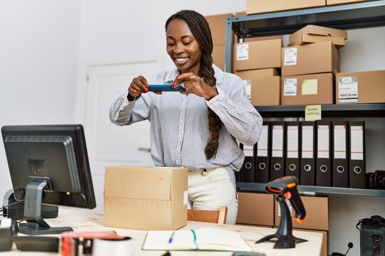 African american woman ecommerce business worker make photo to package at office