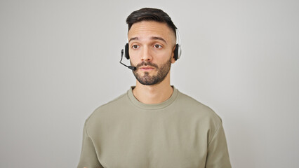 Young hispanic man call center agent wearing headset working over isolated white background