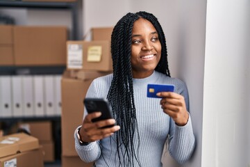 African american woman ecommerce business worker using smartphone and credit card at office