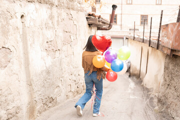 shot of an attractive young woman holding a bunch of balloons on the Street 