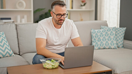 Fototapeta na wymiar Grey-haired man using laptop at home