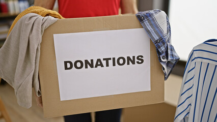 Senior woman volunteer's hands holding package of clothes for charity center, a heartwarming act of...