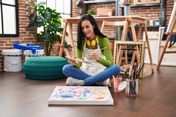 Young caucasian woman artist smiling confident sitting on floor drawing at art studio