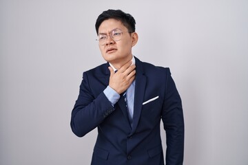 Young asian man wearing business suit and tie touching painful neck, sore throat for flu, clod and infection