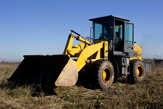 Yellow rusty Bulldozer at work in the field